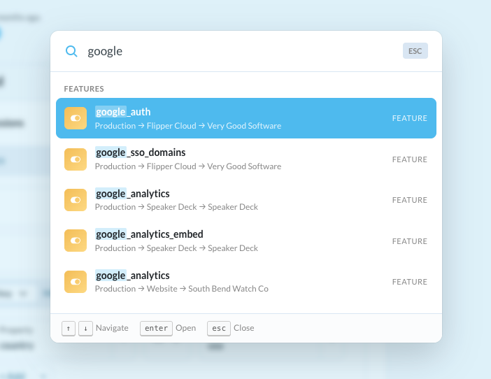 Screenshot of the Command+K search modal showing search results for 'google' with several feature flags listed including google_auth, trusted_domains, and google_analytics, each showing their environment and project breadcrumb.